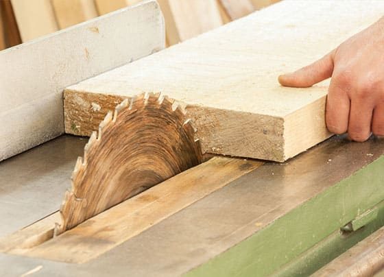 Carpenter Using Saw — H&D Building Supplies in Heatherbrae, NSW
