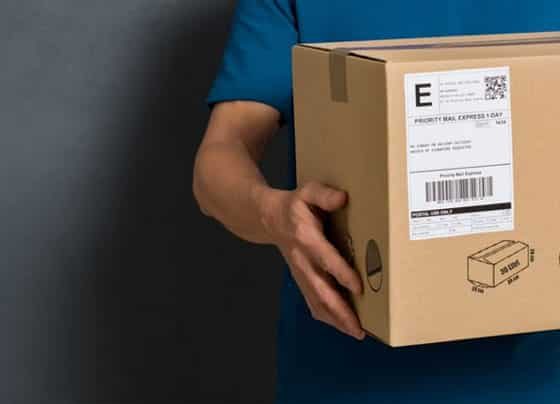 Delivery Man Holding Package — H&D Building Supplies in Heatherbrae, NSW