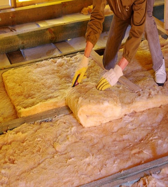 Man Thermally Insulating House With Attic Glass Wool — H&D Building Supplies in Heatherbrae, NSW
